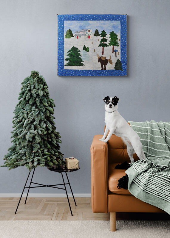 wall hanging of house and snowy scene on wall with small tree and dog
