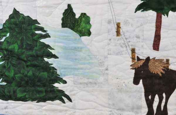 close up of quilted fabric wall hanging with horse and pond