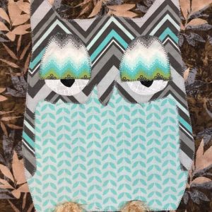sleepy teal forest owl wall hanging with brown leaves