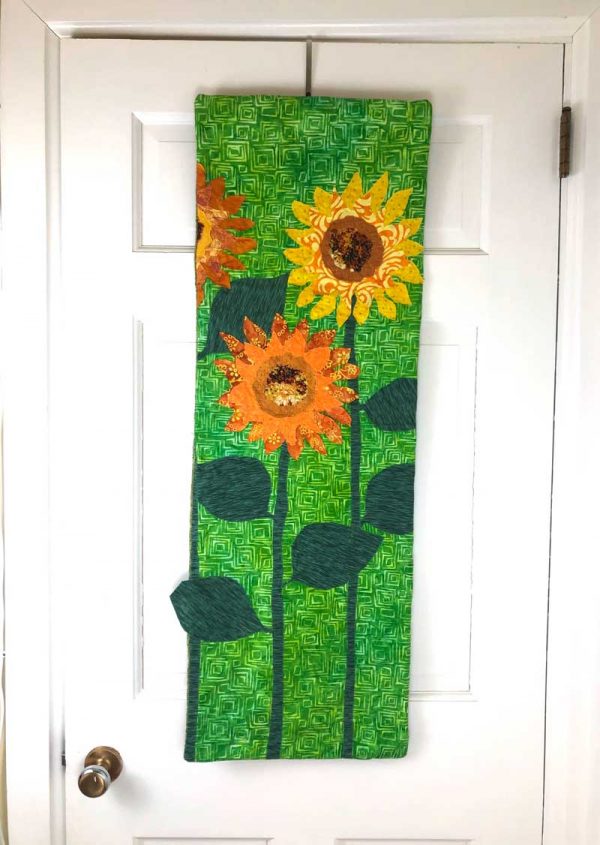 fabric wallhanging of fabric sunflowers on door