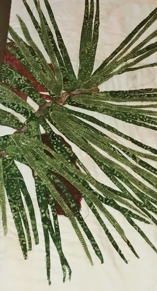 up-close of sewn pine needles on large wallhanging