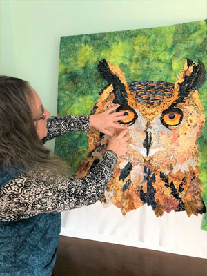 Martha working on large owl fabric picture
