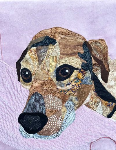 This fabric pet memorial wallhanging shows a brown and tan dog resting on the arm of her favorite rose arm chair.